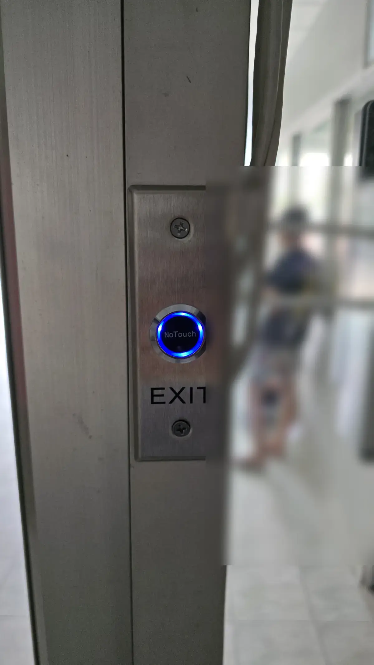 The no-touch exit button beside the door